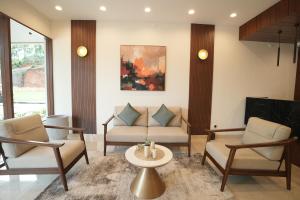 a living room with chairs and a couch and a table at Mihas Hotels and Resorts in Malappuram