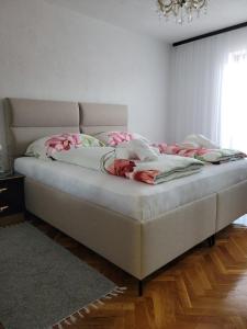 a bed with pink flowers on it in a bedroom at Kuća Latice in Tomislavgrad