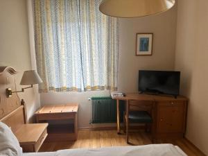 a bedroom with a desk with a television and a bed at Breitenfelderhof in Breitenfeld an der Rittschein