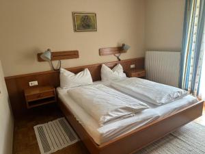 a bedroom with a bed with white sheets and pillows at Breitenfelderhof in Breitenfeld an der Rittschein