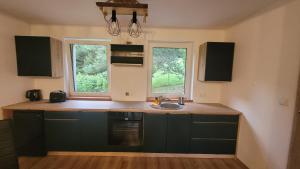 a kitchen with a sink and two windows at Niebo do wynajęcia in Kłodzko +6 photos