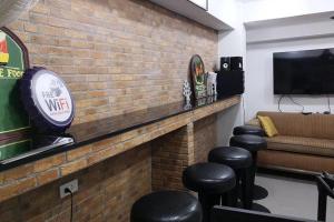 a bar with stools and a brick wall at 101 SEOUL HOSTEL (101 โซล โฮสเทล) in Bangkok