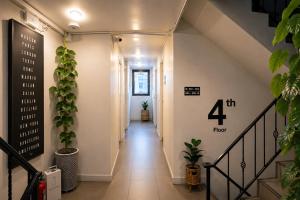 a hallway with stairs and plants at 101 SEOUL HOSTEL (101 โซล โฮสเทล) in Bangkok