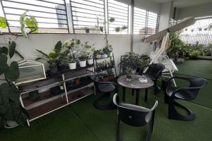 a room with a table and chairs and potted plants at 101 SEOUL HOSTEL (101 โซล โฮสเทล) in Bangkok