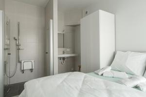 a white bedroom with a shower and a bed at Oud Peer in Peer