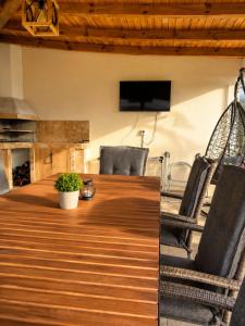 a dining room table with chairs and a tv at На Село in Garmen