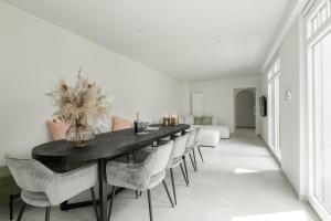 a dining room with a black table and white chairs at Oud Peer in Peer
