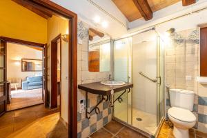 a bathroom with a toilet and a glass shower at Finca Son Xona in Capdepera +21 photos