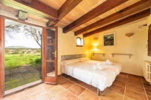 a bedroom with a bed and a sliding glass door at Finca Son Xona in Capdepera