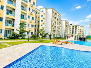 a swimming pool with benches in front of a building at Residential Capital Plus in Accra
