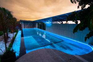 a swimming pool with blue lighting on a house at Mia Hotel in Ga Trảng Bôm