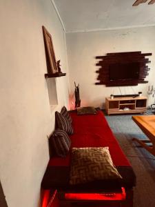 a bedroom with a red bed and a flat screen tv at Makao Home in Arusha