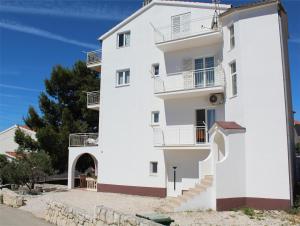 a white building with stairs in front of it at Apartment Mila in Primošten