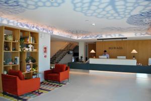 eine Lobby mit Rezeption und zwei Stühlen in der Unterkunft Hotel Delfin Azul in A Lanzada