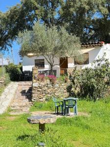a table and bench in a yard with a house at Casa Papiqui in Fuenteheridos
