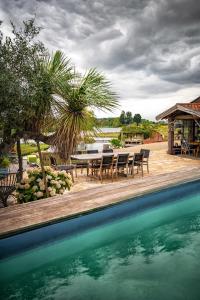a pool with chairs and a table next to a house at Guesthouse Ensenada in Schoondijke