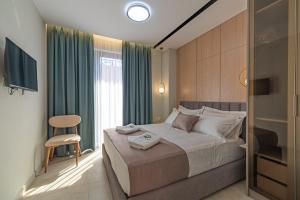 a bedroom with a bed and a chair and a window at Evianamar in Shëngjin +291 photos