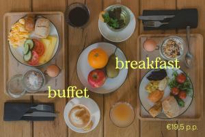 a wooden table topped with plates of breakfast food at Pods by The Usual Rotterdam in Rotterdam