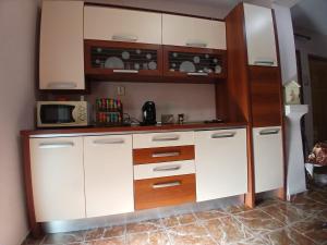 a kitchen with white cabinets and a microwave at Teo&Alex in Năvodari