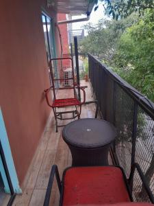 a porch with two chairs and a table on a balcony at apartamento elegante in Fernando de la Mora