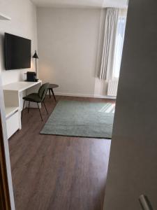 a living room with a desk and a chair and a television at Roxi Roosevelt in Antwerp