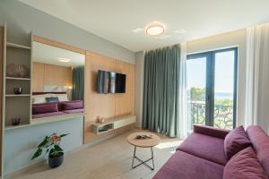 a living room with a purple couch and a bed at Evianamar in Shëngjin