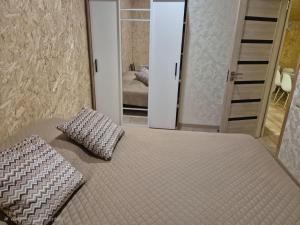 a bedroom with a bed with two pillows and a mirror at Modern Apartment Near Sevan Lake in Sevan