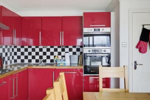a red kitchen with red cabinets and appliances at Marina View in Plymouth
