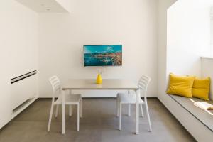 a dining room with a white table and chairs at The Seven Mansions in Genoa