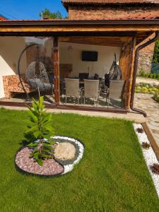 a garden with a patio with a table and chairs at На Село in Garmen