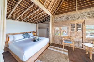 a bedroom with a bed and a table and a chair at Dolce Vita Villa in Sampalan