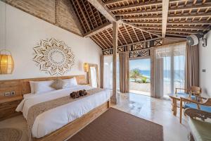 a bedroom with a large bed and a large window at Dolce Vita Villa in Sampalan