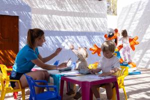 a woman and a little boy sitting at a table at Invisa Hotel Club Cala Verde in Es Figueral Beach +46 photos