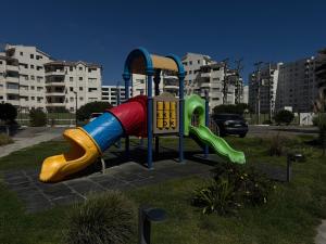 a playground with a slide in a park at Moderno departamento cercano a playa in La Serena