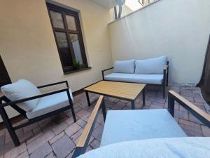 a patio with chairs and a table and a couch at Apartmán Gabriel in Kežmarok