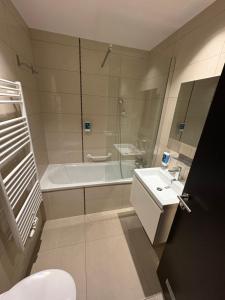a bathroom with a tub and a toilet and a sink at Roxi Roosevelt in Antwerp