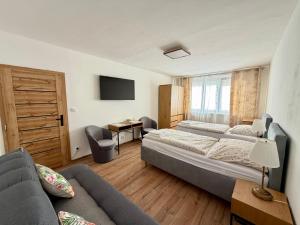 a bedroom with two beds and a couch at Apartmánový byt Flower in Kadaň