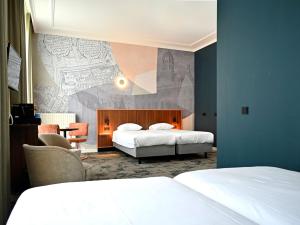 a bedroom with two beds and a wall with a mural at Fletcher Hotel Paleis Stadhouderlijk Hof in Leeuwarden