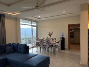 a living room with a couch and a table with chairs at The Elysian Villa in Bhurban