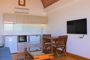 a kitchen with a table with two chairs and a tv at Munahan Otel in Bodrum City