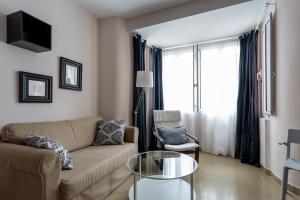 a living room filled with furniture and a tv at Apartamentos Diaber Edificio Constitución in Seville