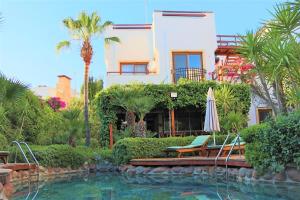 a house with a swimming pool and an umbrella at Munahan Otel in Bodrum City