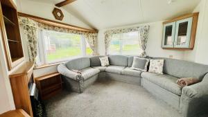 a living room with a couch and two windows at The Hidden Meadow in Ballybofey