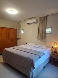 a bedroom with a large bed and a air conditioner at Sítio Quinta da Serra in Guaramiranga