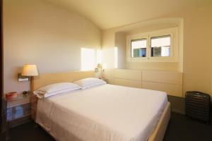 a bedroom with a large white bed with a window at The Seven Mansions in Genoa