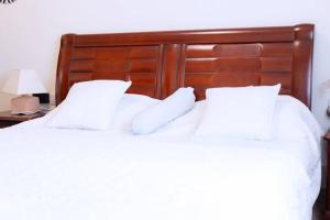 two white pillows on a bed with a wooden headboard at Mariebu Beach Resort in Buhongo +11 photos