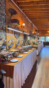 a row of tables in a restaurant with white table skirts at Diamond Koru Hotel in Amasra