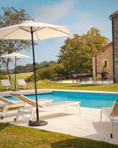 an umbrella and chairs next to a swimming pool at Domaine de Cazal - Gîte 4 pers au coeur d'un Domaine Privé avec Piscine, Nature & Calme près de Sarlat in Saint-Cyprien