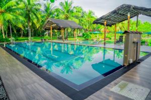 a pool at a resort with palm trees at Neem Tree Boutique Resort in Serukele