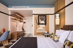 ein Schlafzimmer mit Bett und Ankleidezimmer in der Unterkunft Mural Piraeus Hotel in Piräus